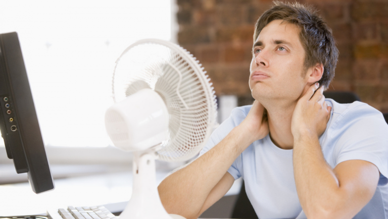 Man uncomfortable in front of fan.