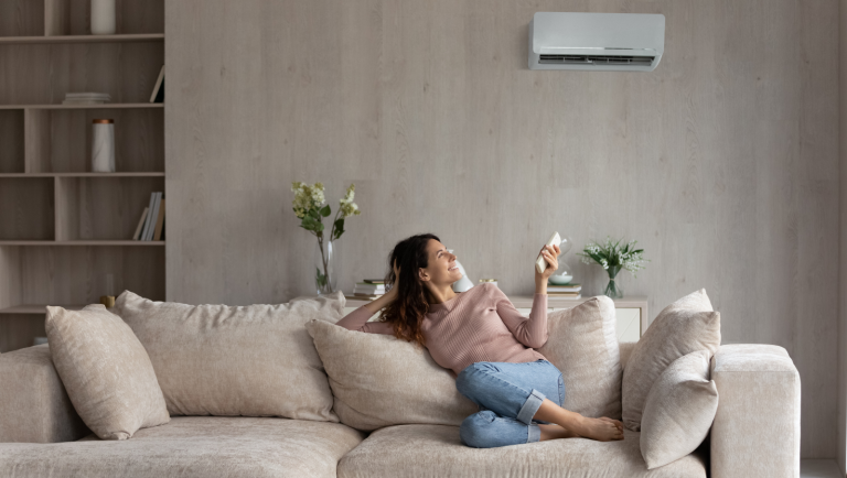 Woman enjoying ductless air conditioning unit in her home.