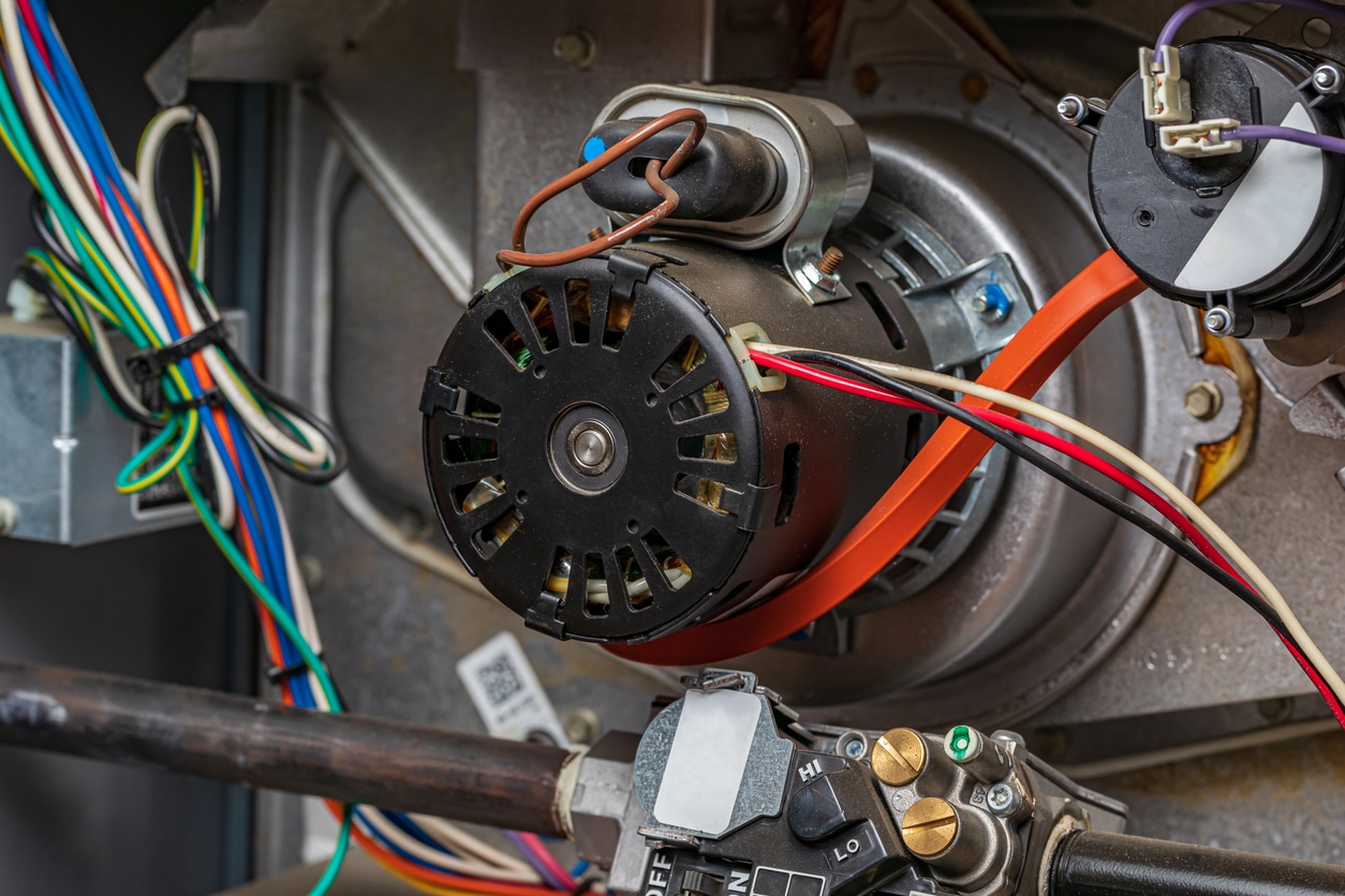 A Handy Bros. technician diagnosing furnace blower motor issues, ensuring proper airflow and efficient heating performance.