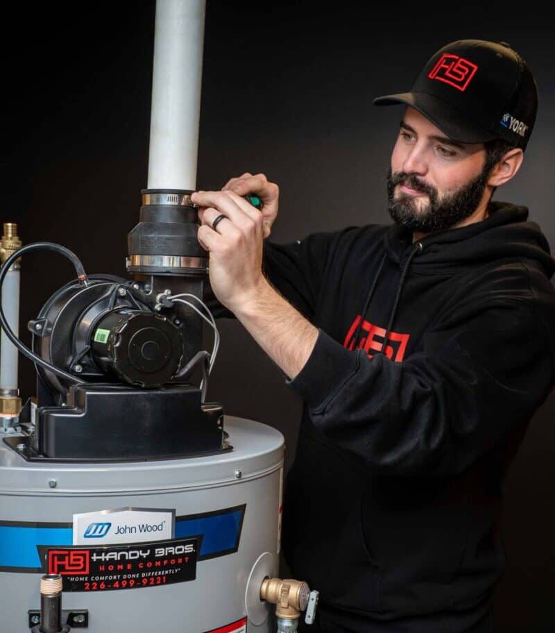 A Handy Bros. technician repairing a water heater to restore reliable hot water supply for the home.