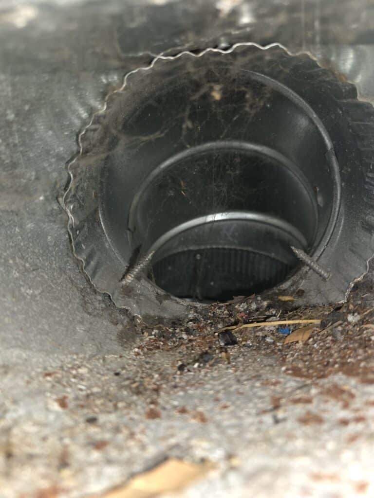 Duct cleaning before photo showing buildup in ductwork