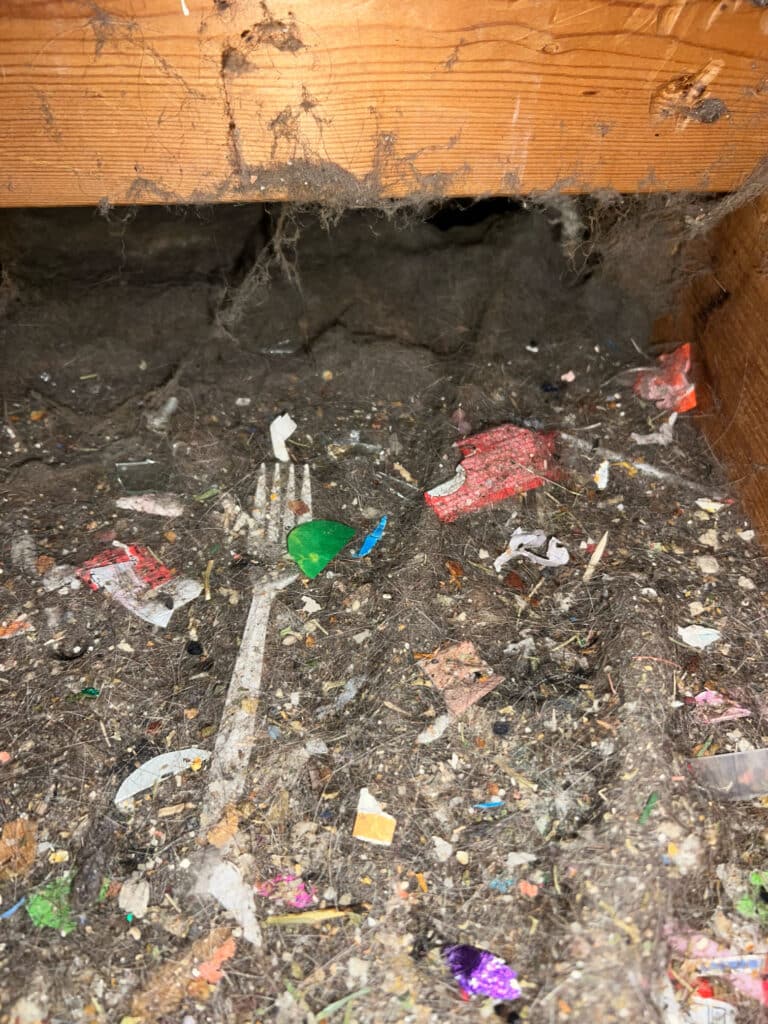 Duct cleaning before photo showing debris in ductwork