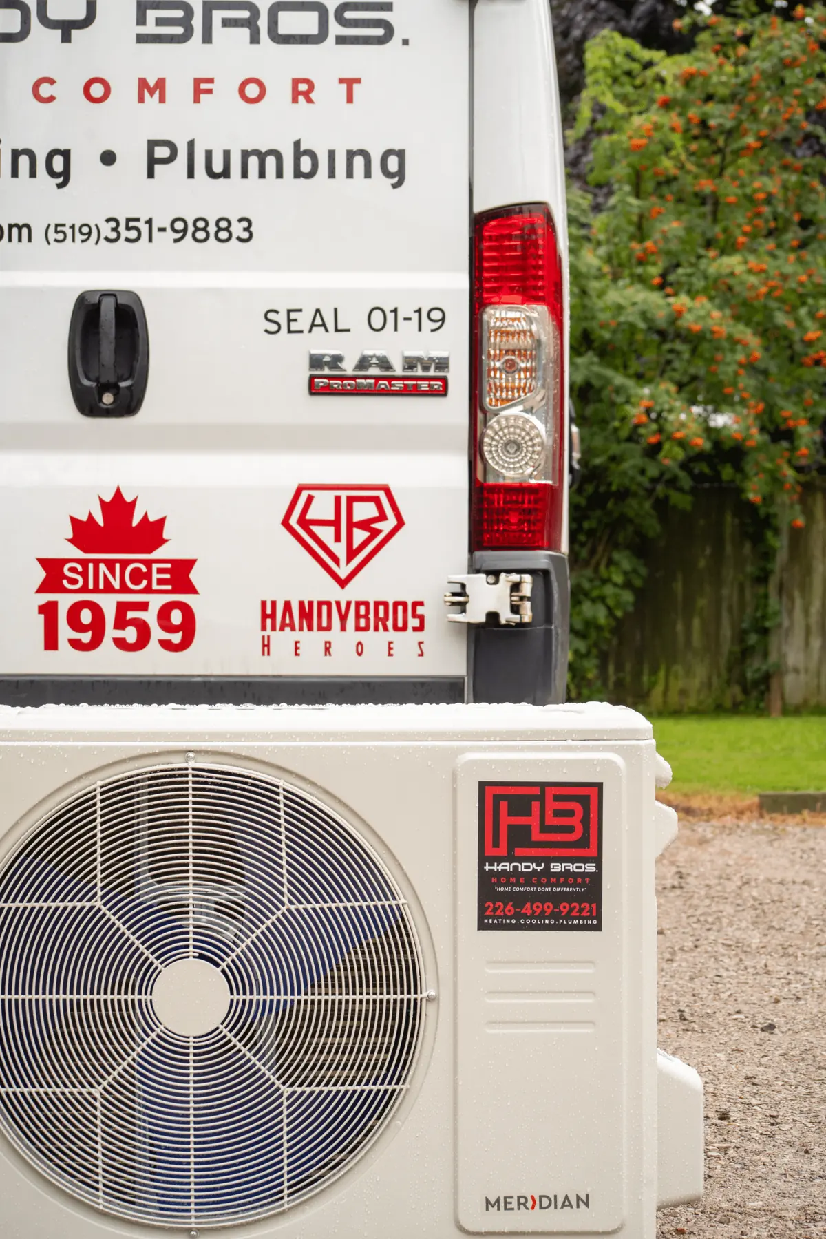 Rear of a white service van with Handy Bros branding and 'Since 1959' logo, next to a large outdoor air conditioning condenser unit in the foreground.